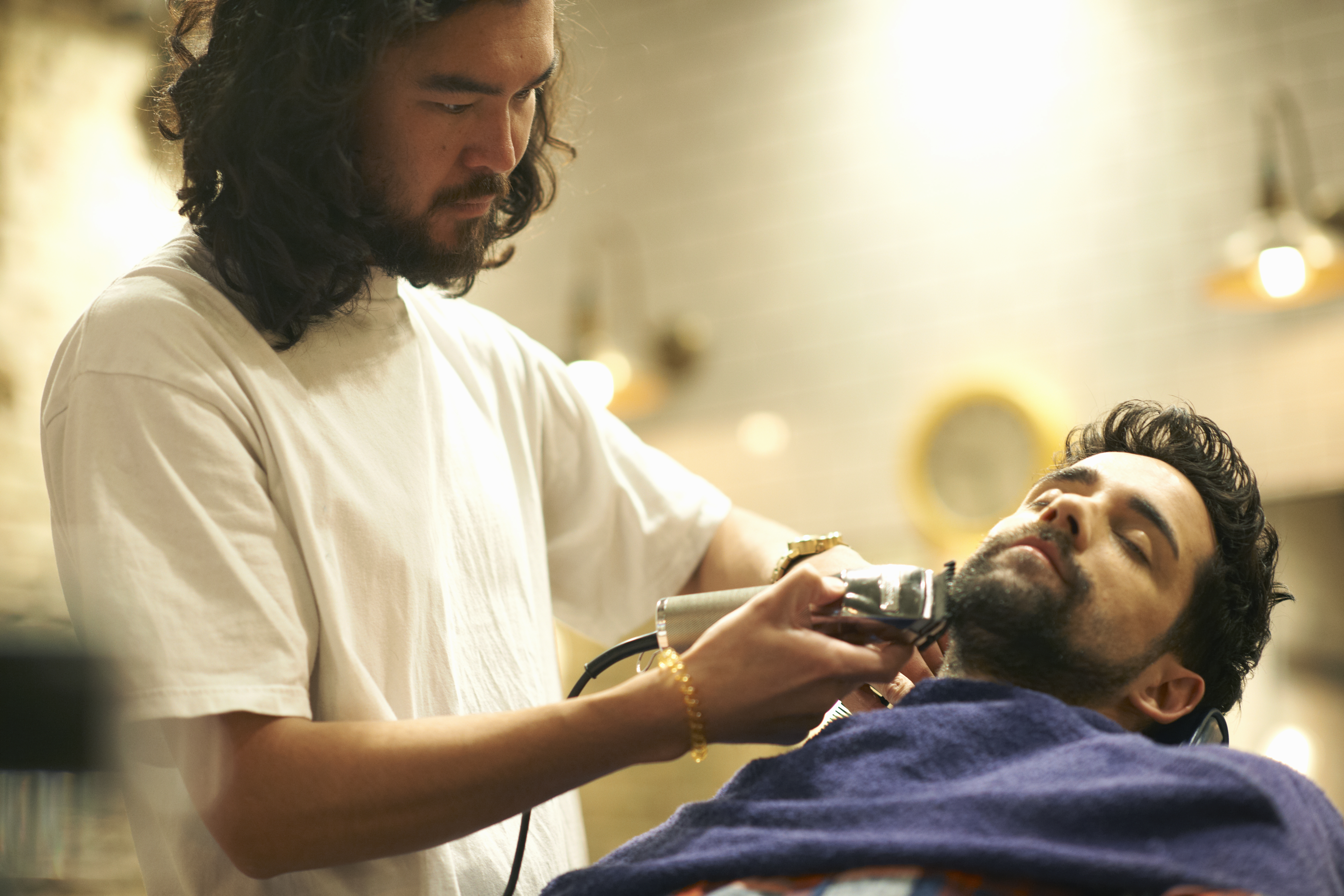 Coiffeur rasant la barbe d'un client